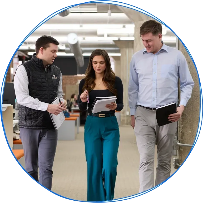 People in a business meeting around a table, using laptops and discussing ideas. Blue and white colors.