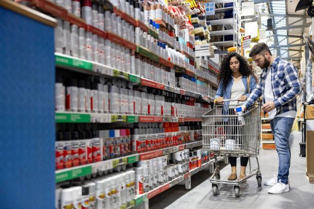 A couple is buying paint at a hardware store.