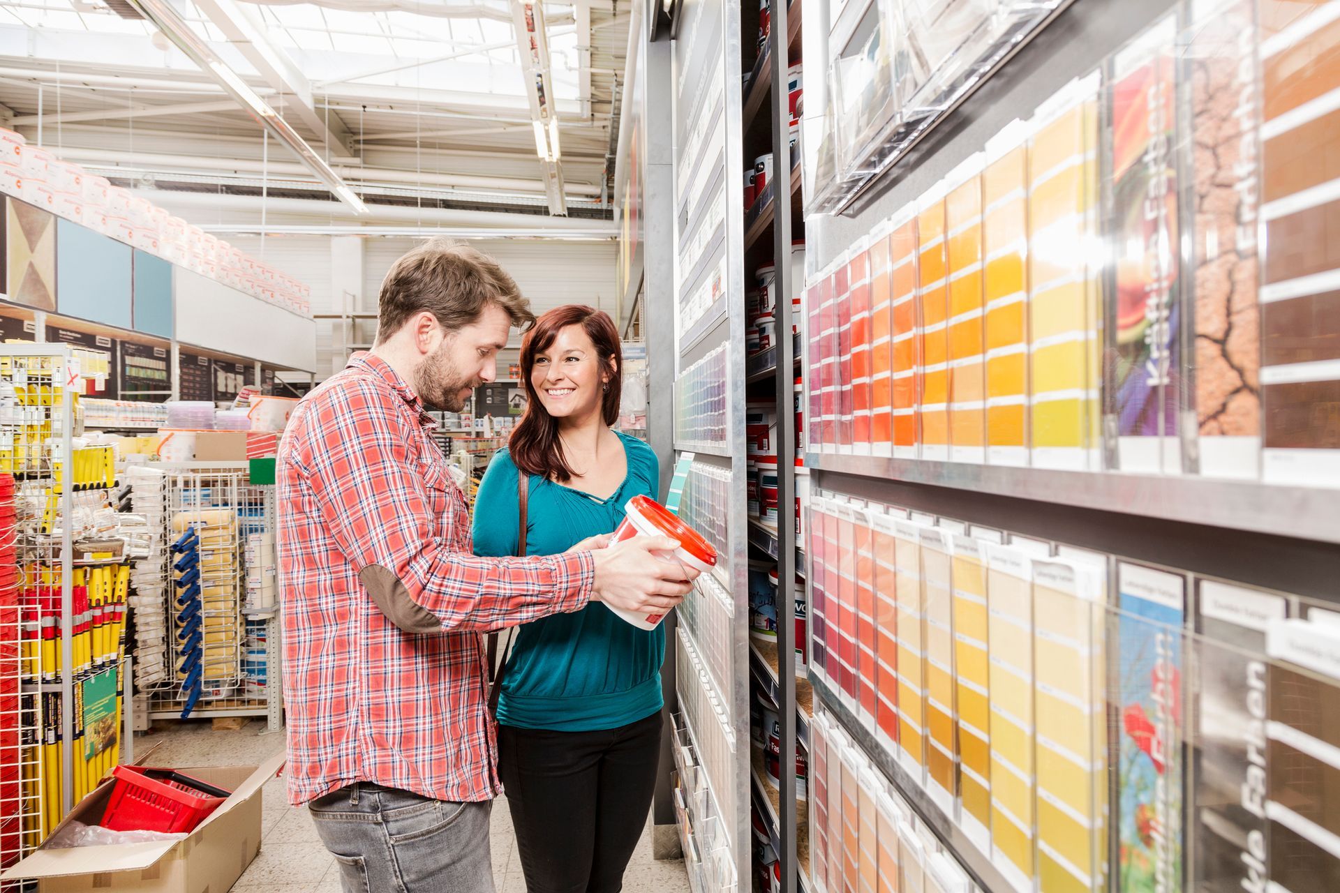 Young couple looking for some wall paint in a hardware store - Paint Store, Hardware Store