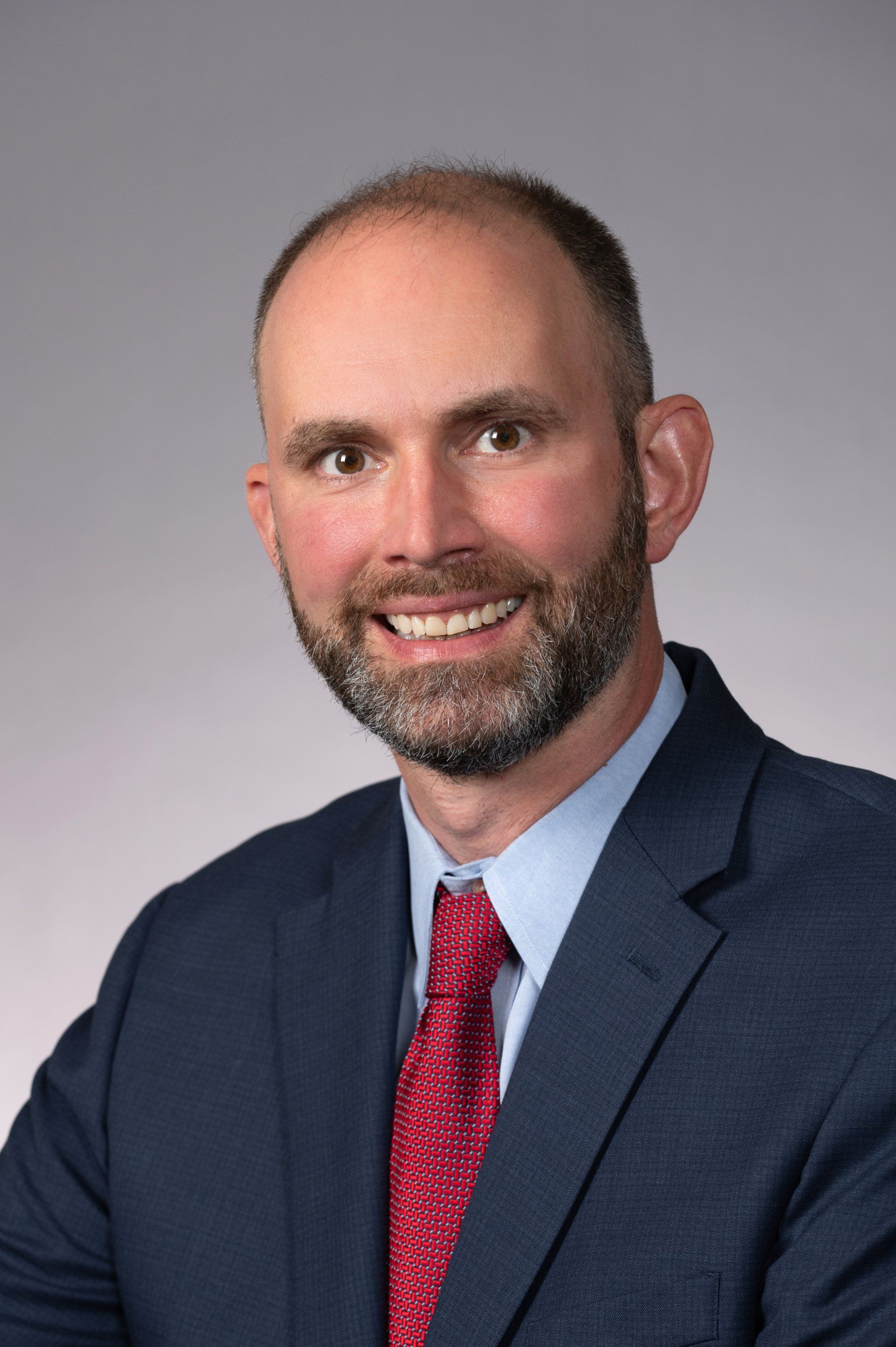 A man in a suit and tie is smiling for the camera.