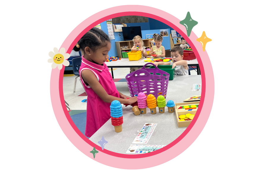 Girl playing with toy ice cream cones at a table in a classroom.