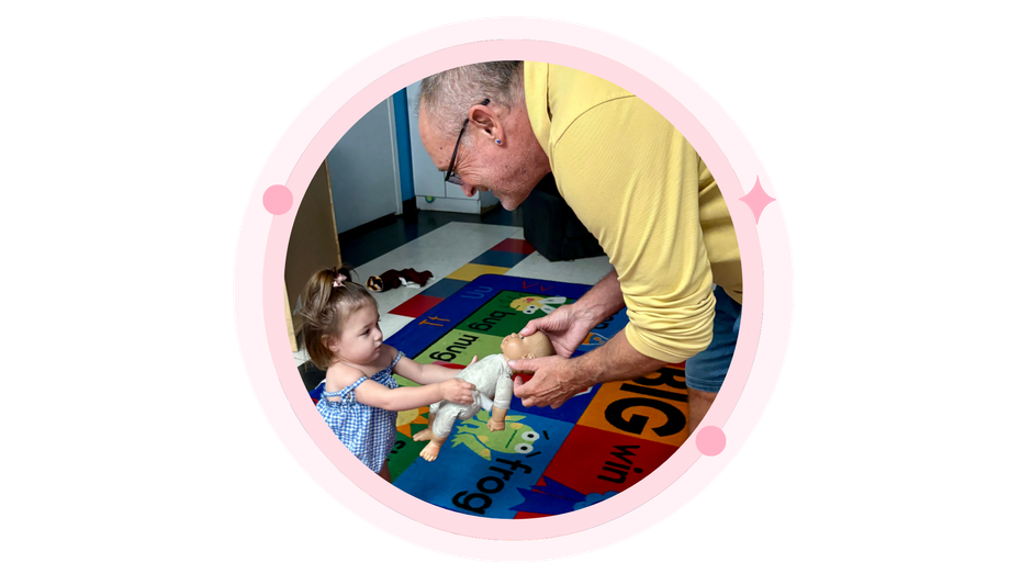 Children and a teacher decorating cookies at a table in a classroom.