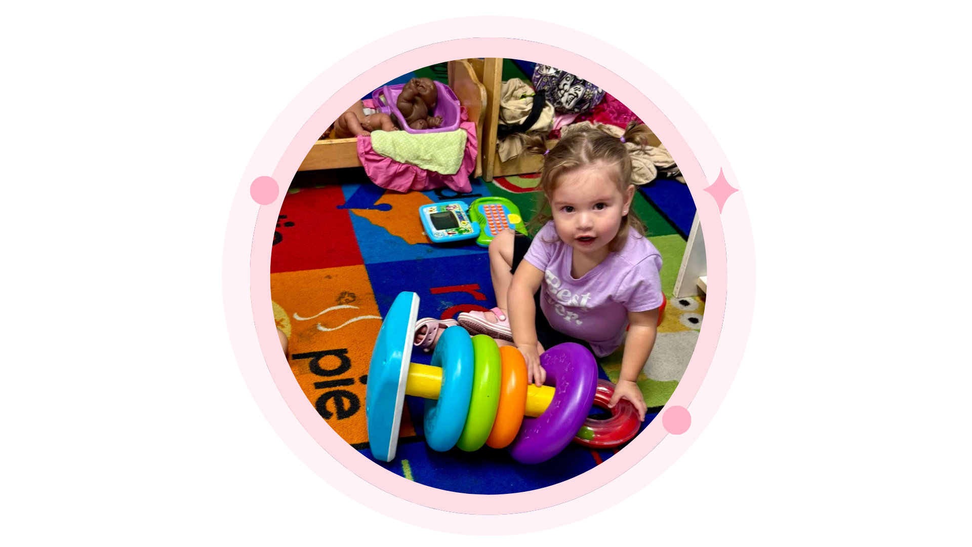 Child at a playground holding a yellow hula hoop, smiling.