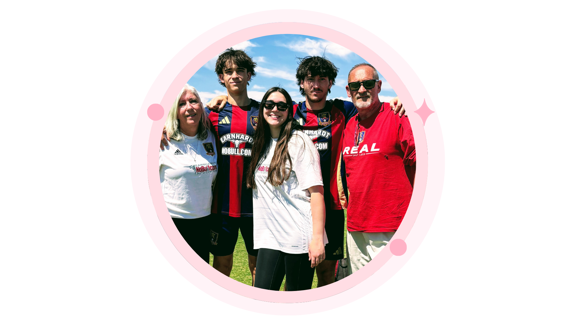 Children decorating cookies at a round table with a teacher. Bright room.