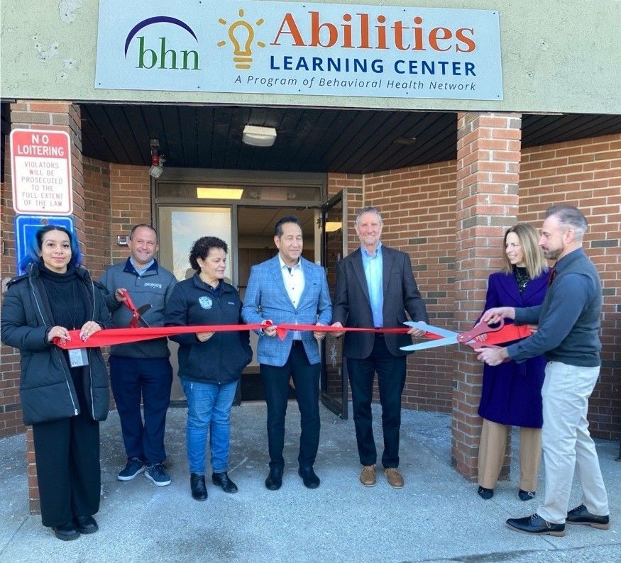 Program staff and local officials cutting the ribbon at the grand opening celebration.