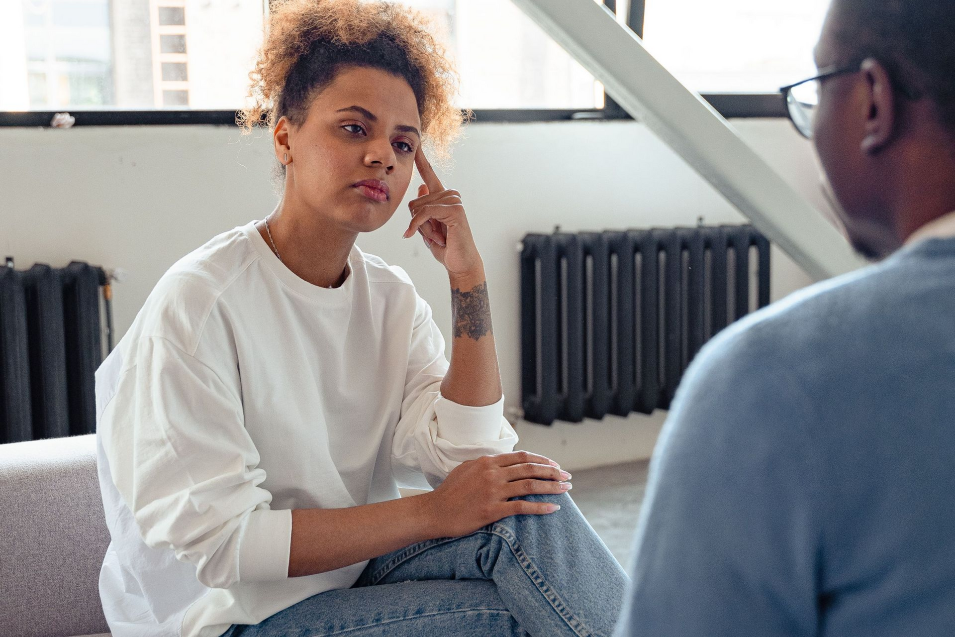 A woman speaking with a mental health professional during a counseling session.