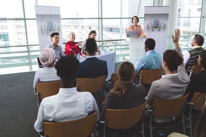 A woman is giving a presentation to a group of people in a conference room.