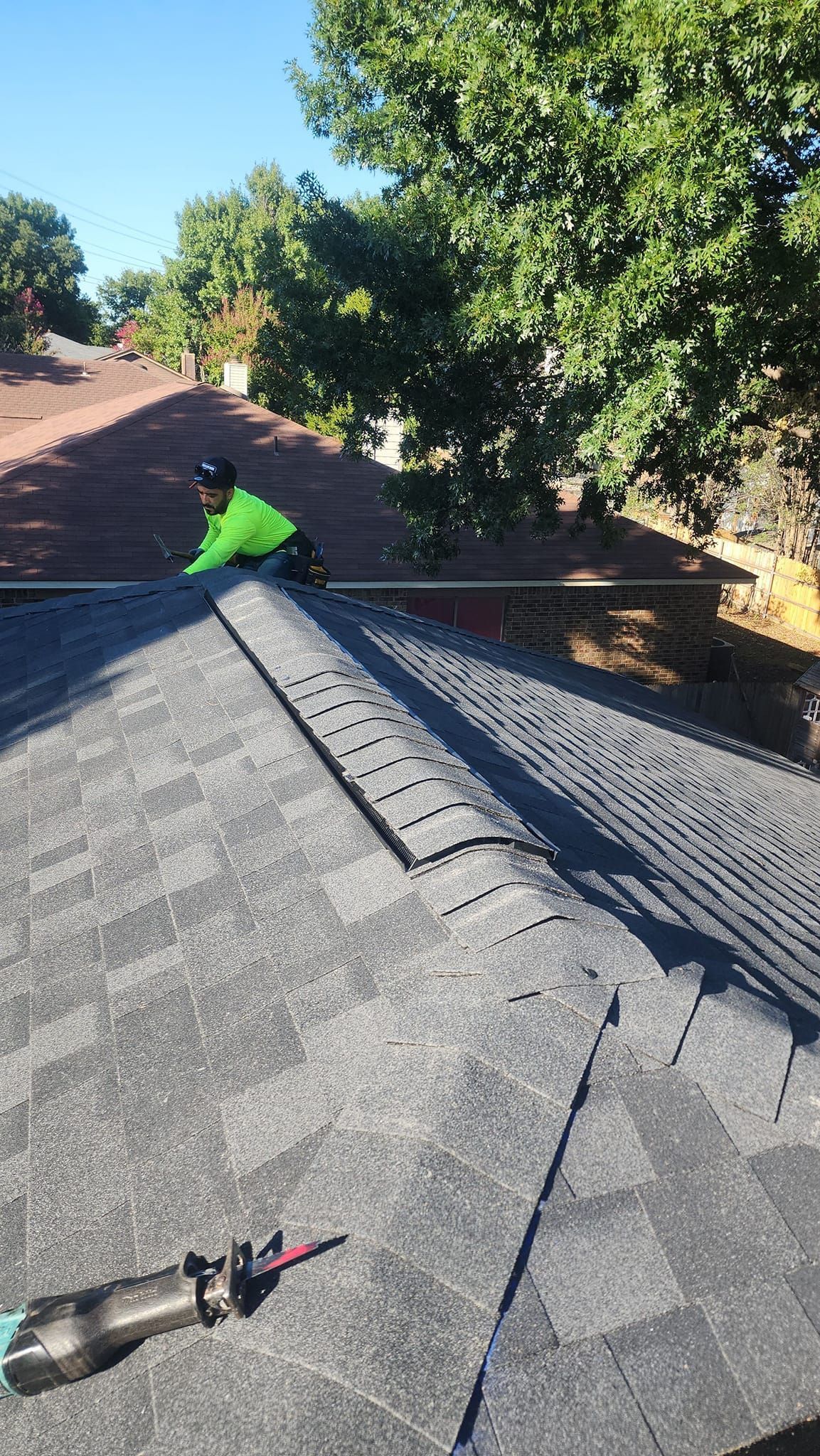 A man is working on the roof of a house.