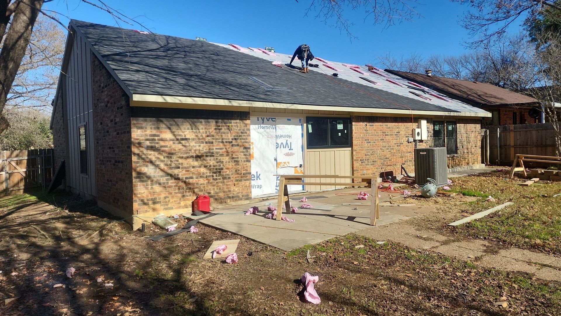 A man is working on the roof of a house.
