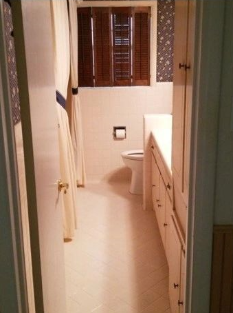 A bathroom with a toilet , sink and window