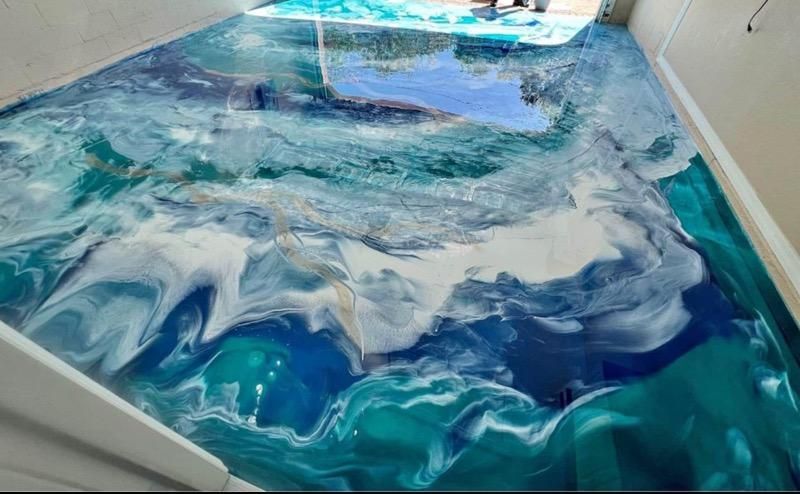 A blue and white floor with a painting of waves on it.