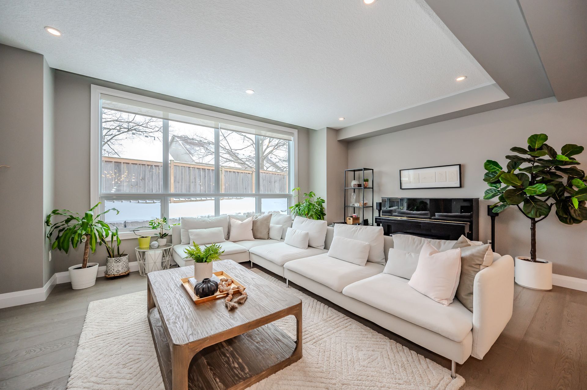 A living room with a couch , coffee table , and piano.