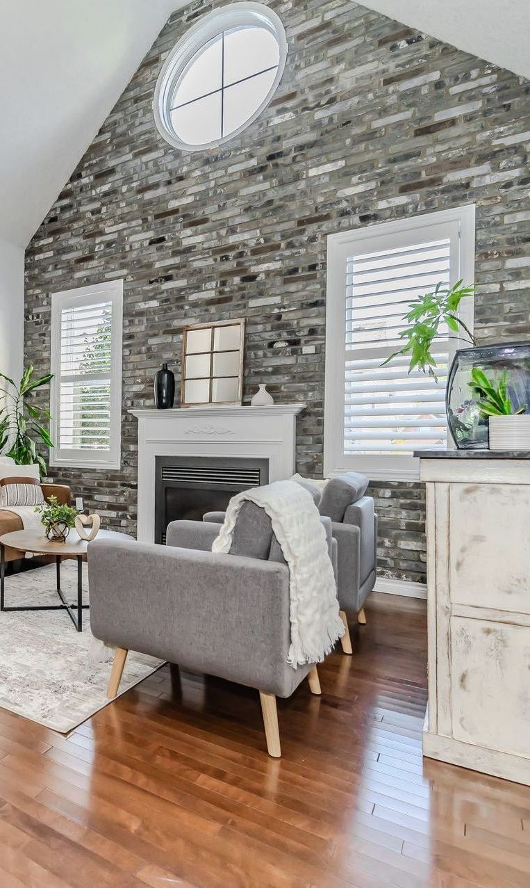 A living room with a fireplace , coffee table , and mirror.