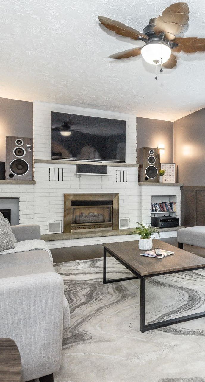 A living room with a fireplace , coffee table , and mirror.