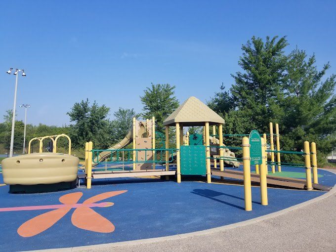 A playground in a park with a butterfly on the ground