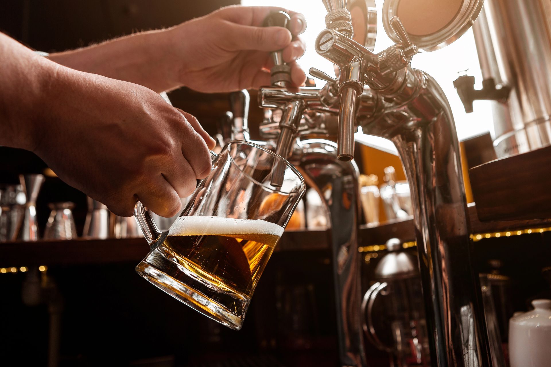 A man is pouring beer into a glass at a bar.