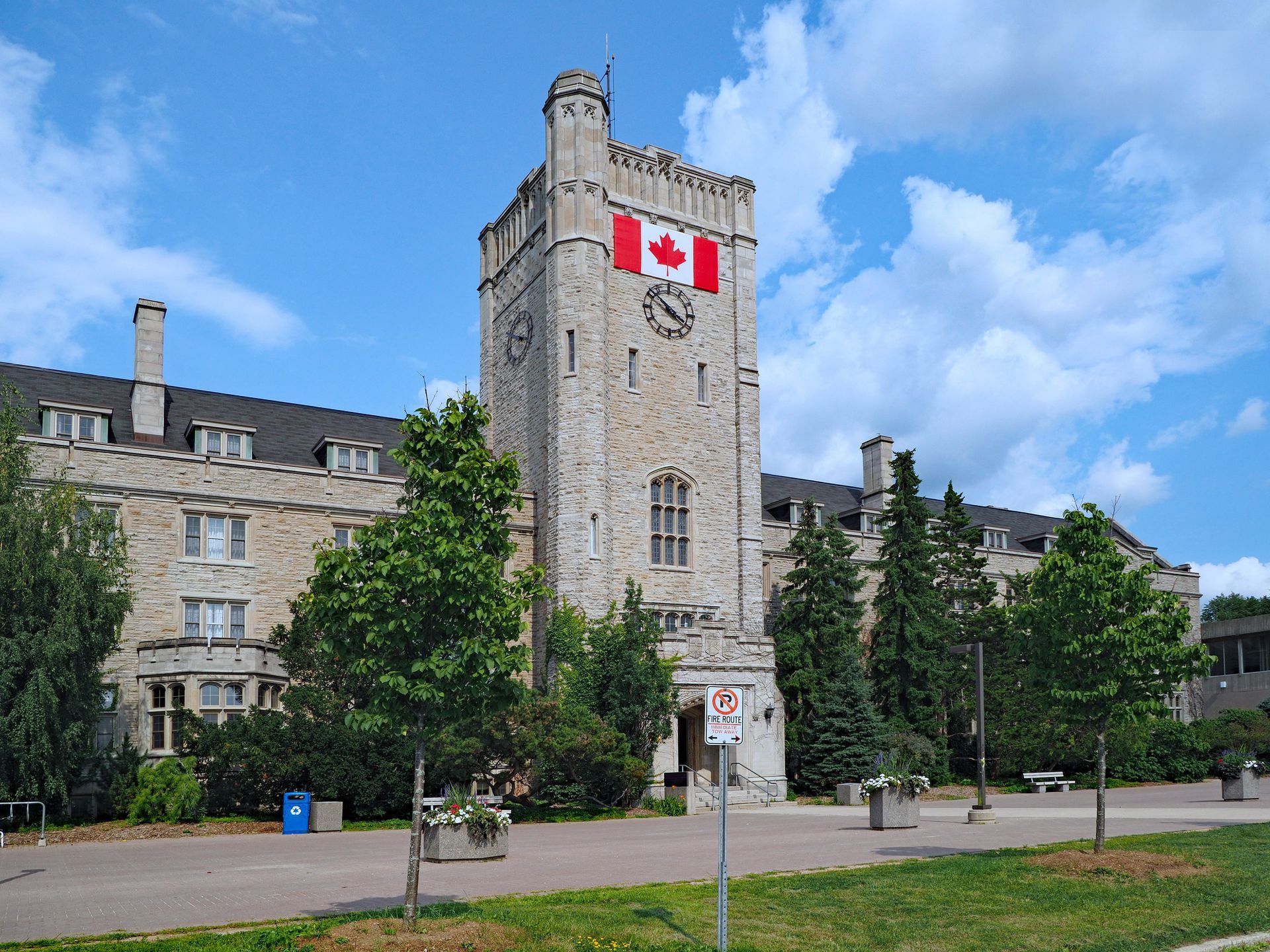 A clock tower with a canadian flag on top of it