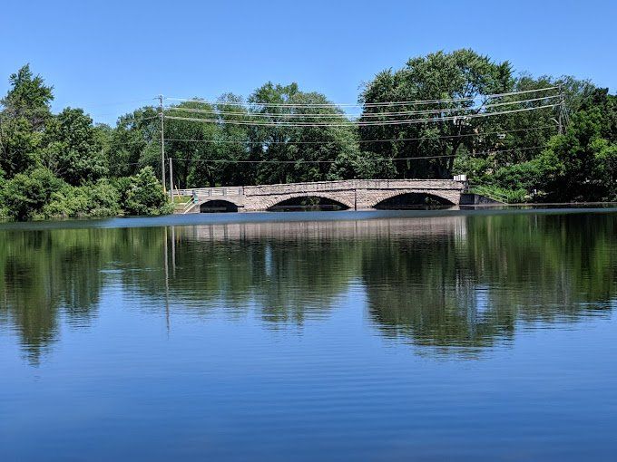 A bridge over a lake with trees in the background