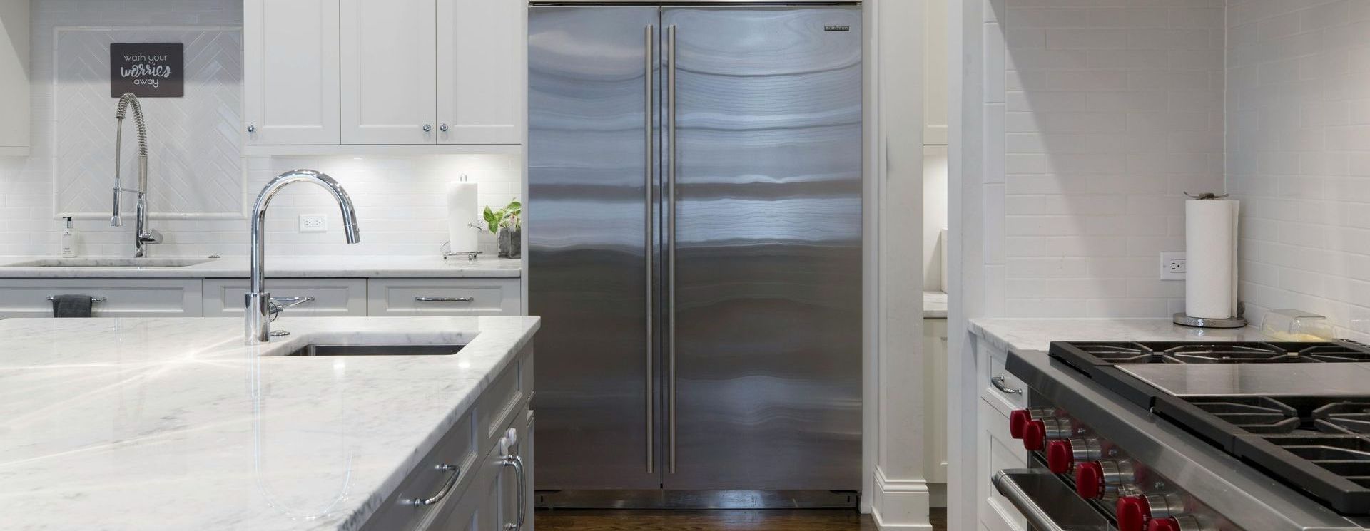 A kitchen with stainless steel appliances and white cabinets.