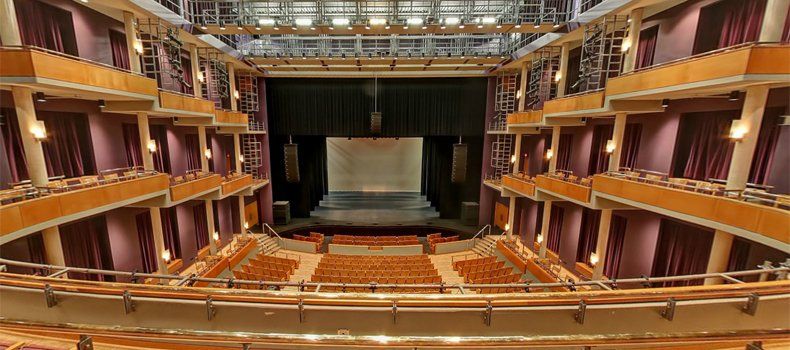 A large auditorium with a stage and rows of seats.