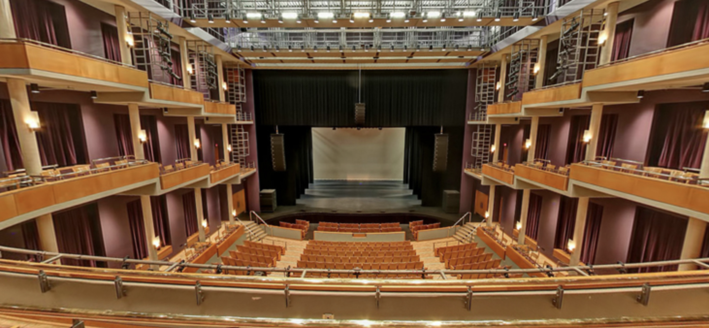 A large auditorium with a stage and rows of seats.