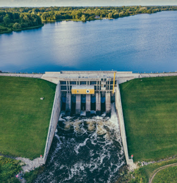 An aerial view of a dam with water coming out of it.