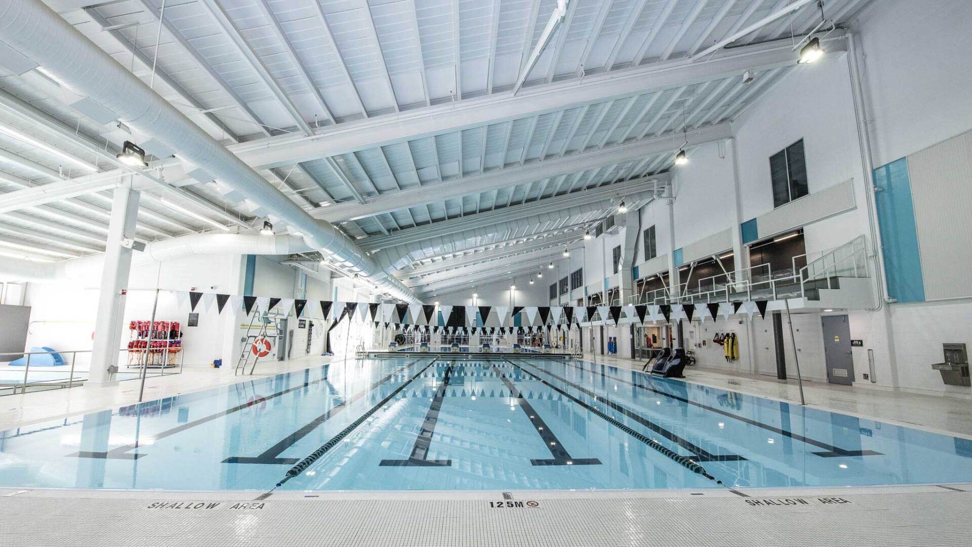 A large indoor swimming pool with a ceiling that is very high.