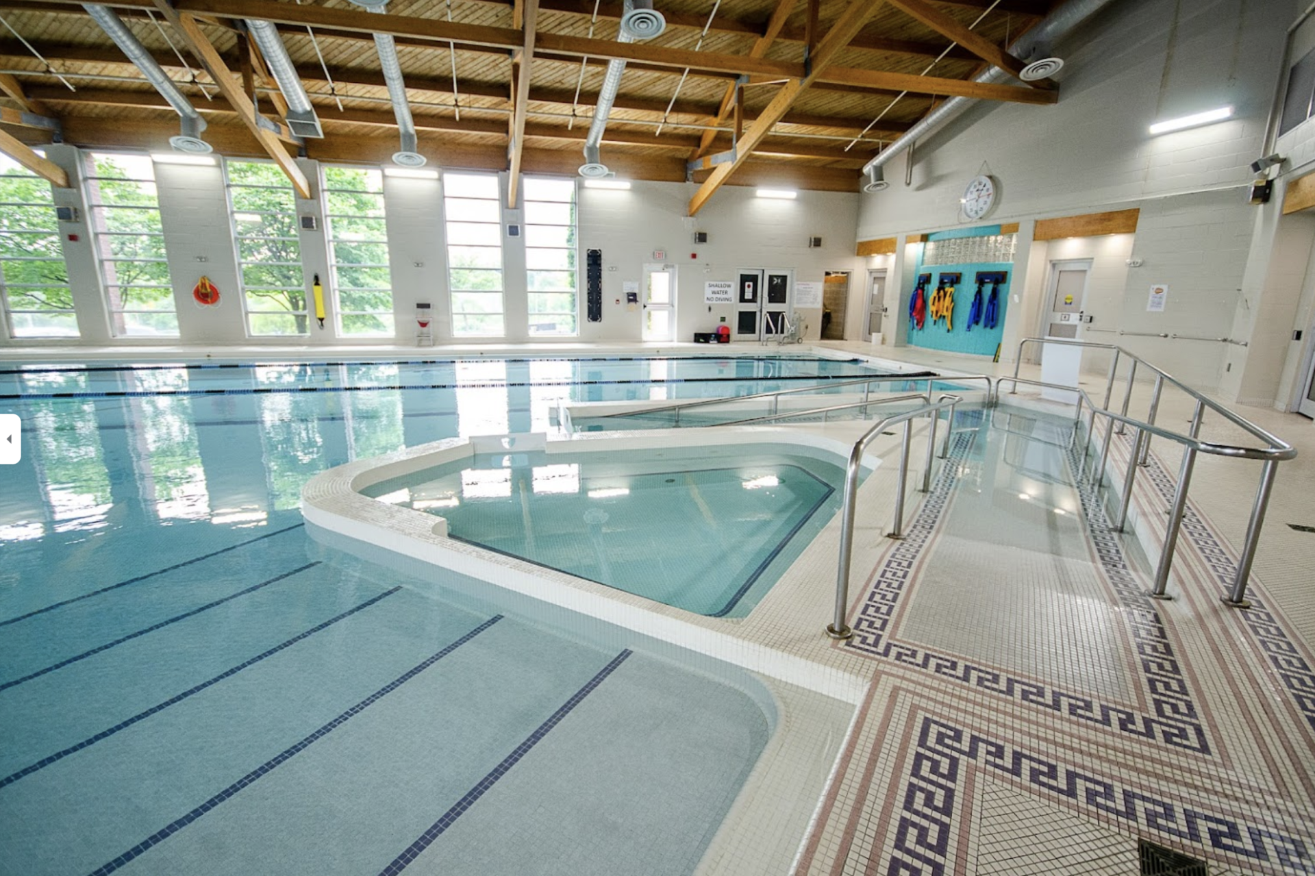 A large indoor swimming pool with a handicapped ramp
