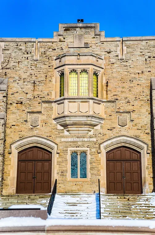 A large brick building with a balcony and stairs leading up to it.