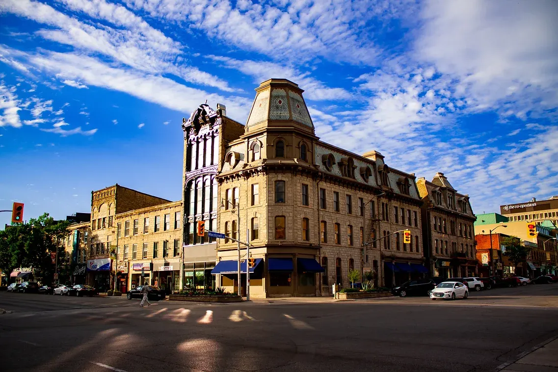 A large building is sitting on the corner of a city street.