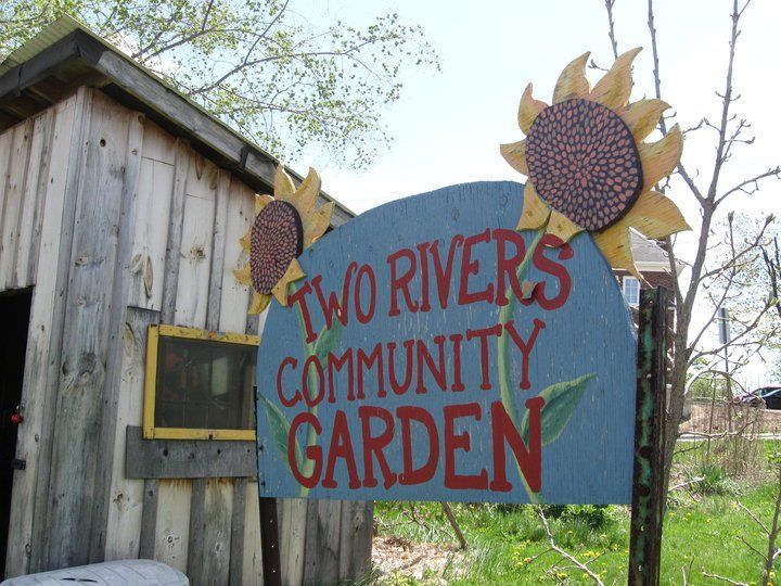A sign that says two rivers community garden on it