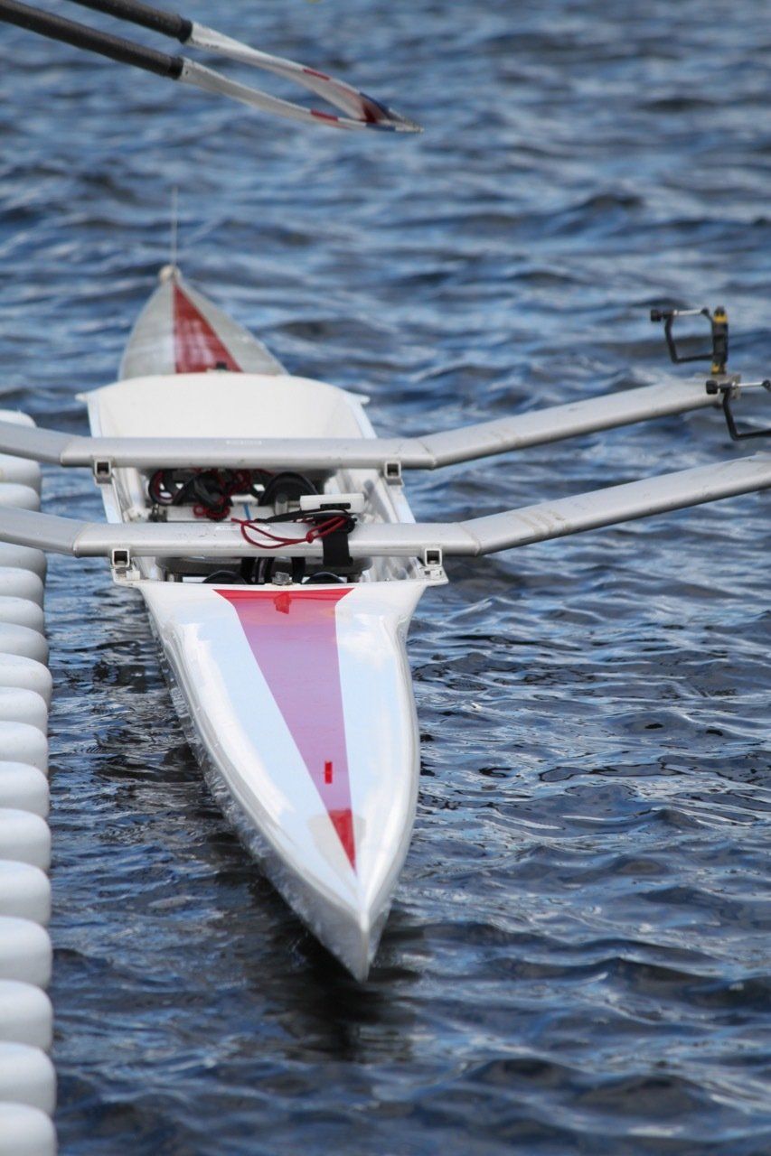 A white and red rowing boat is in the water