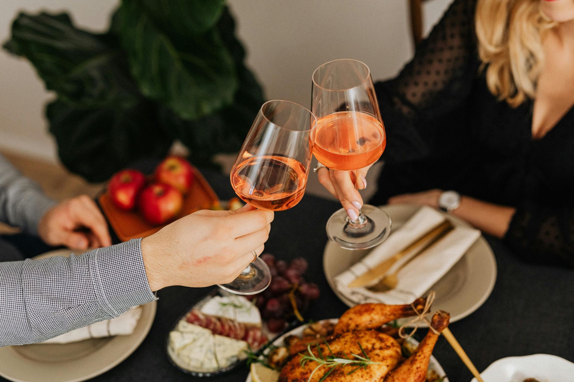 A group of people are sitting at a table toasting with wine glasses.