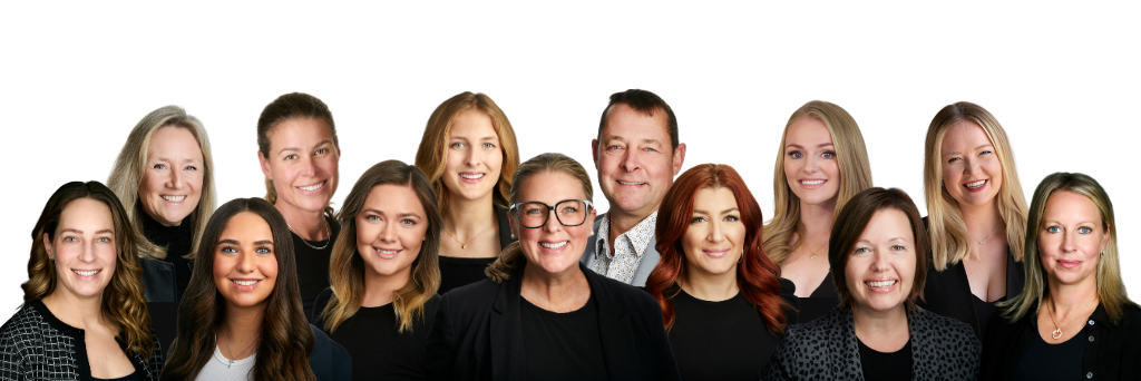 Group of smiling people, mostly women, against a white background.