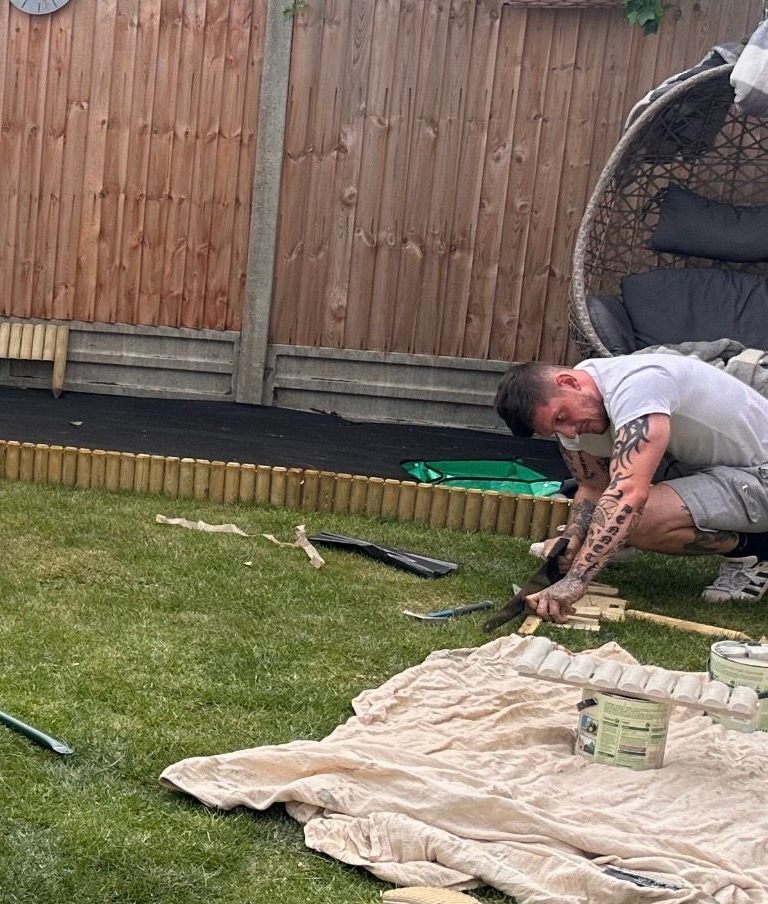 Wooden border fitted and painted for a  children's play area in the garden