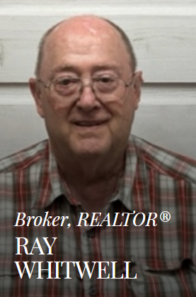 Ray Whitwell, a broker and REALTOR, wearing glasses and a plaid shirt, smiling.