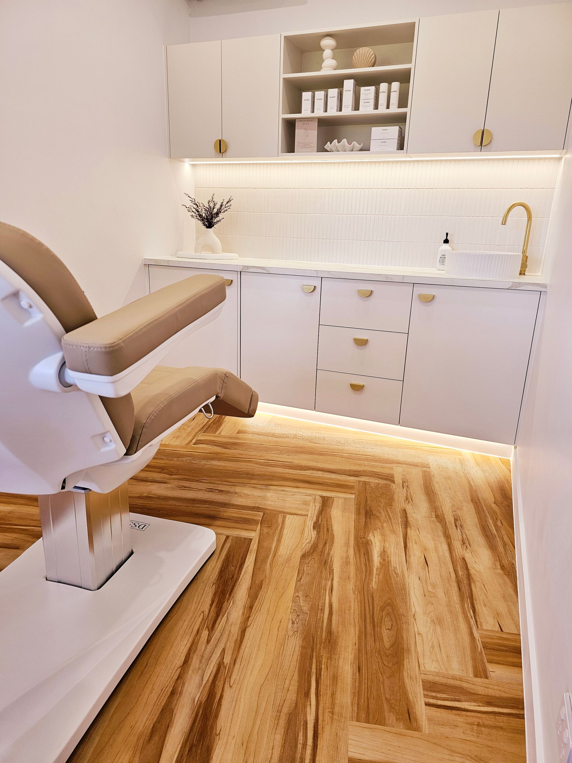 There Is A Chair In The Middle Of A Room With A Wooden Floor — Elysian Aesthetics Injectables in Robina, QLD  