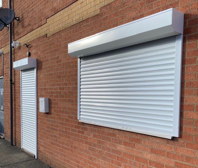 white window and door roller security shutters on shop