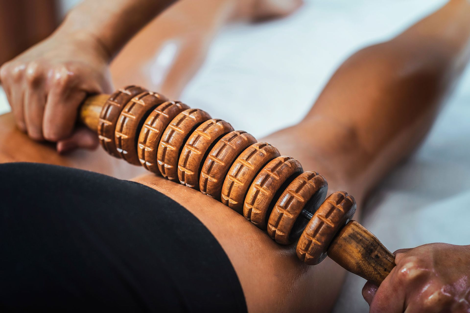 A woman is getting a massage with wood therapy