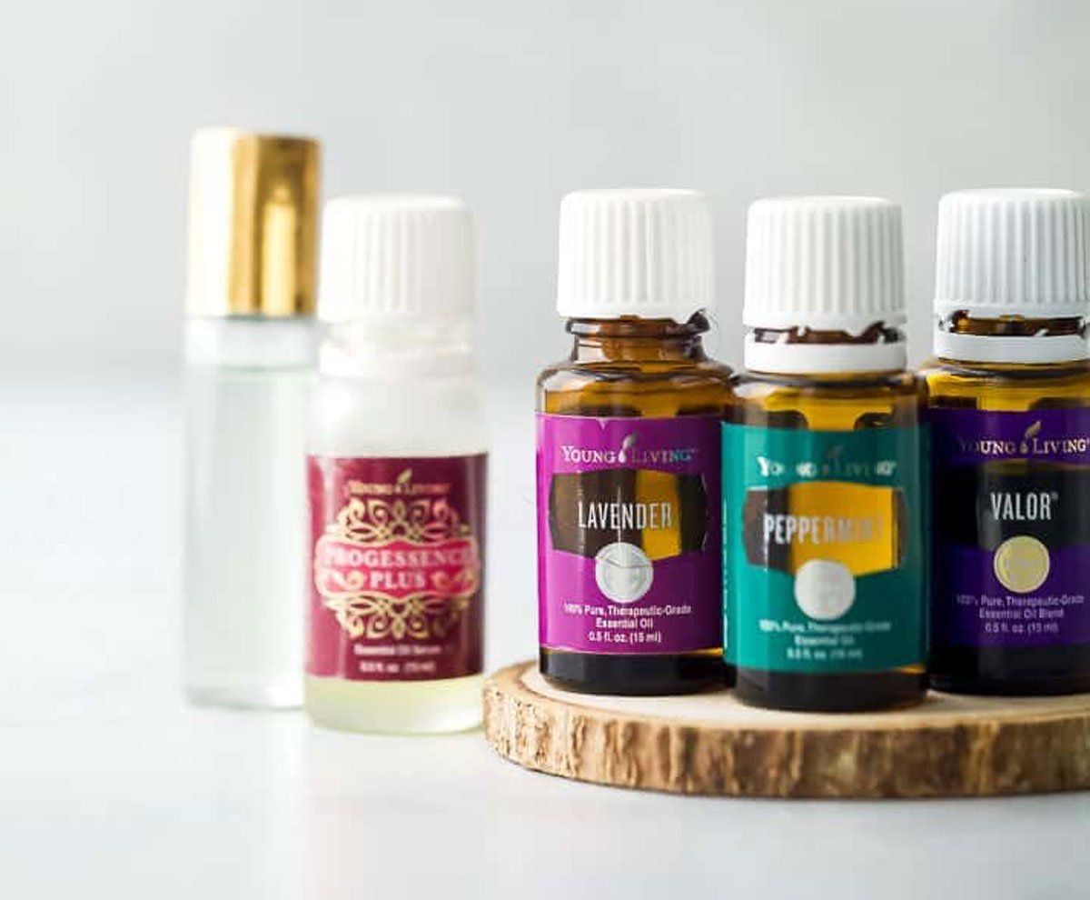 Four bottles of essential oils are sitting on a wooden tray.