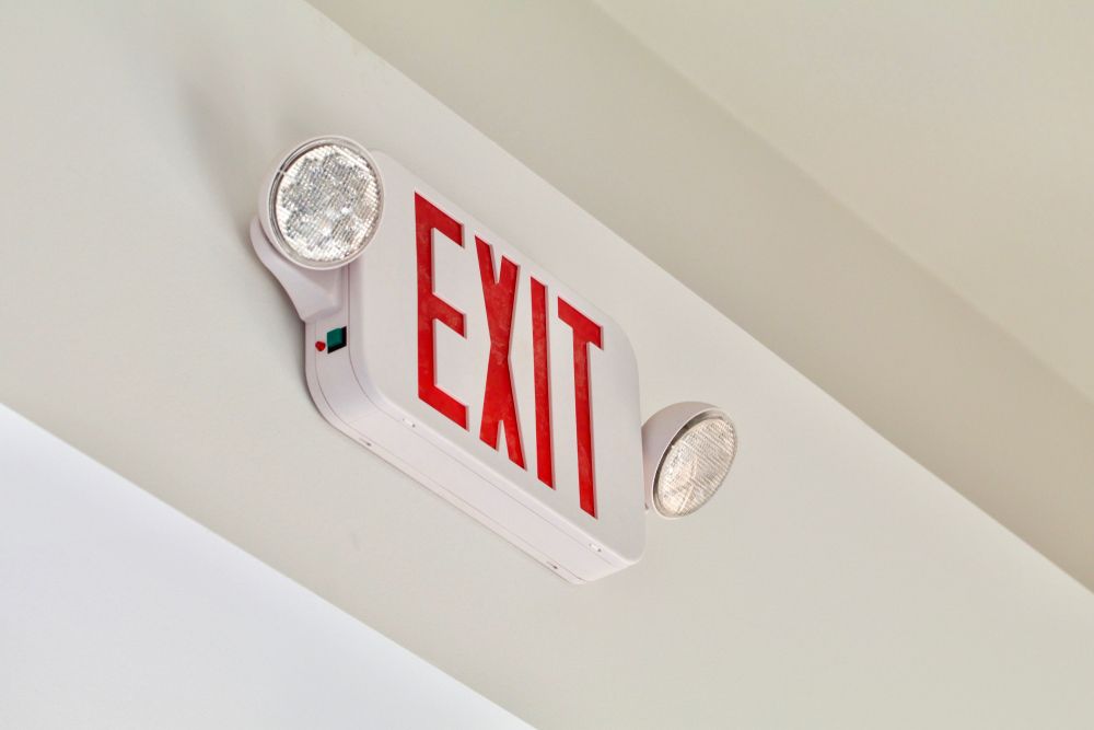 A Red and White Exit Sign Is Hanging from The Ceiling — Stellar Test and Tag in Tamworth, NSW