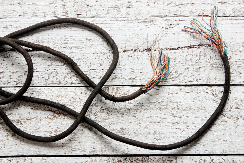 A Broken Cable Is Laying on A Wooden Table — Stellar Test and Tag in Tamworth, NSW