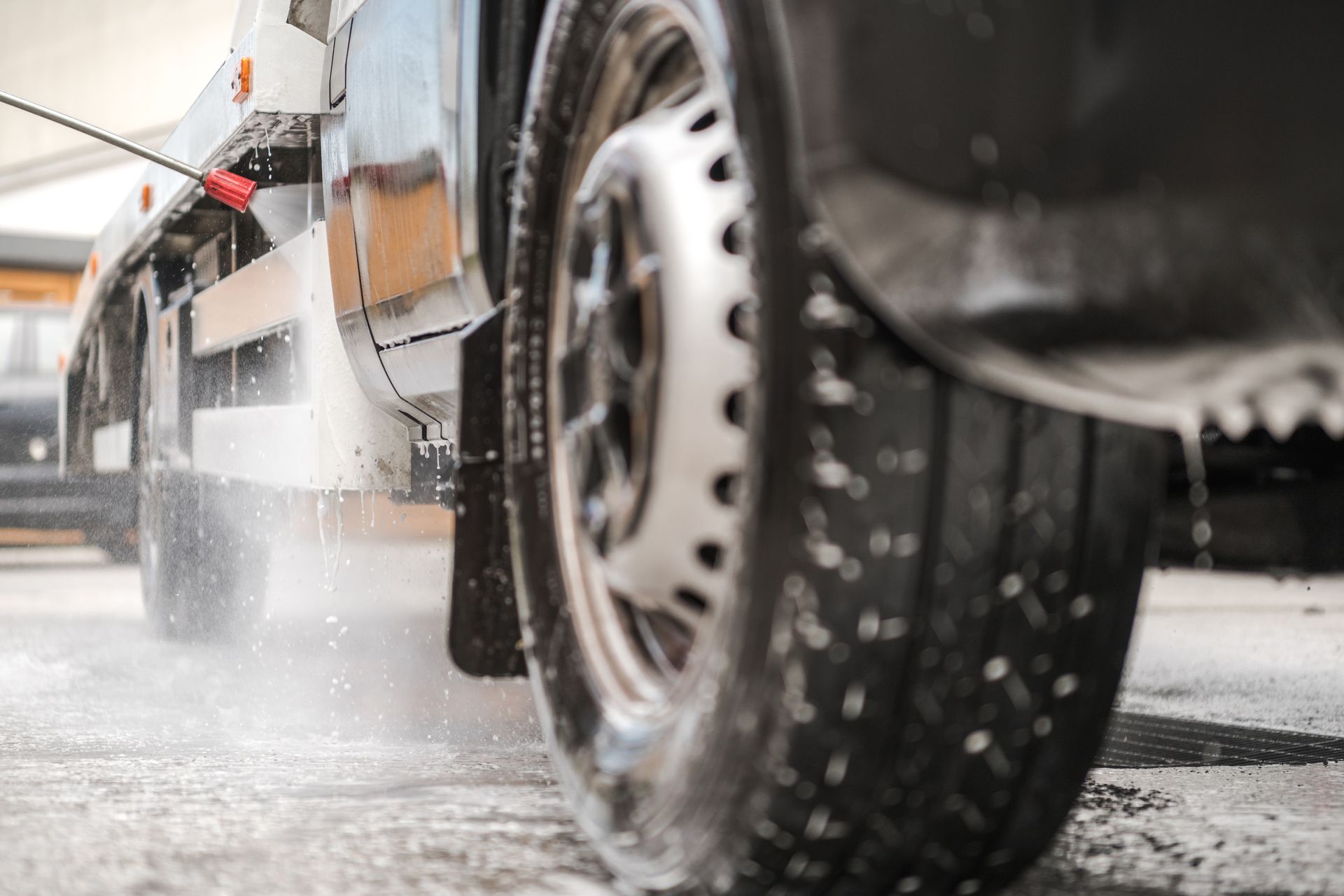 A truck is being washed with a high pressure washer.