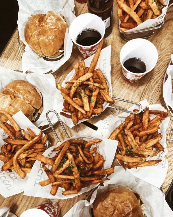 A table topped with hamburgers and french fries.