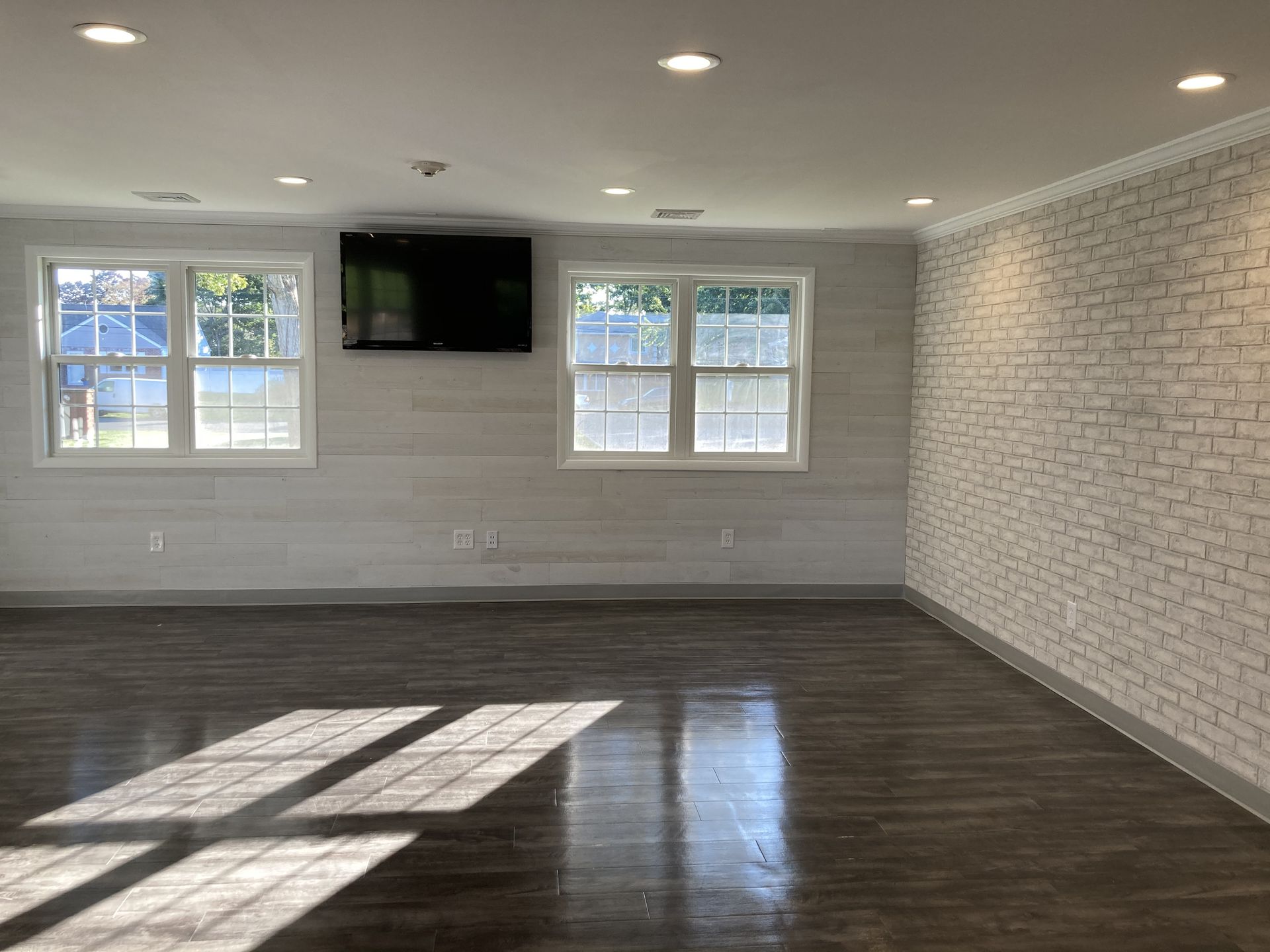 an empty room with a brick wall and a flat screen tv