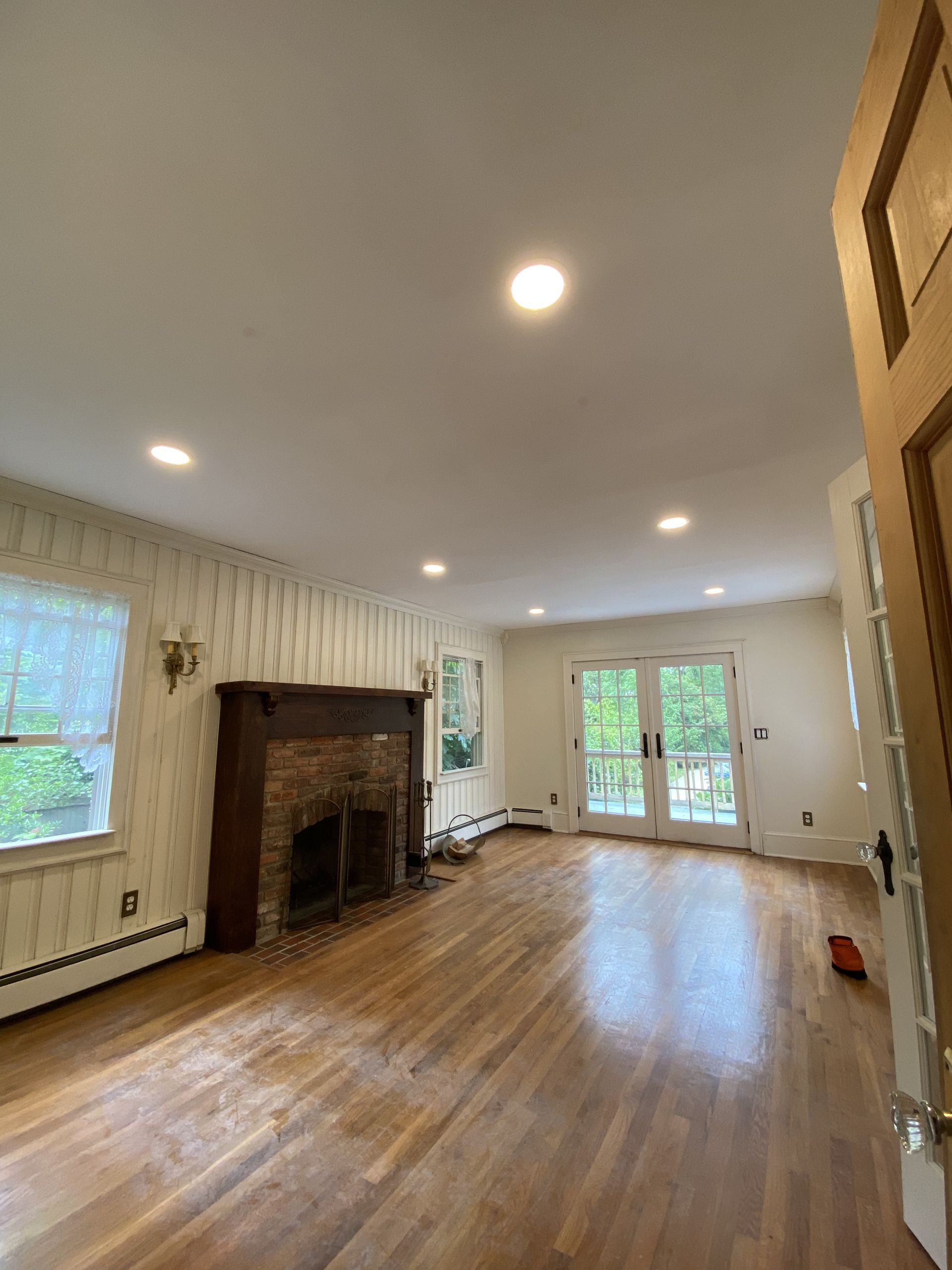 an empty living room with a fireplace and sliding glass doors