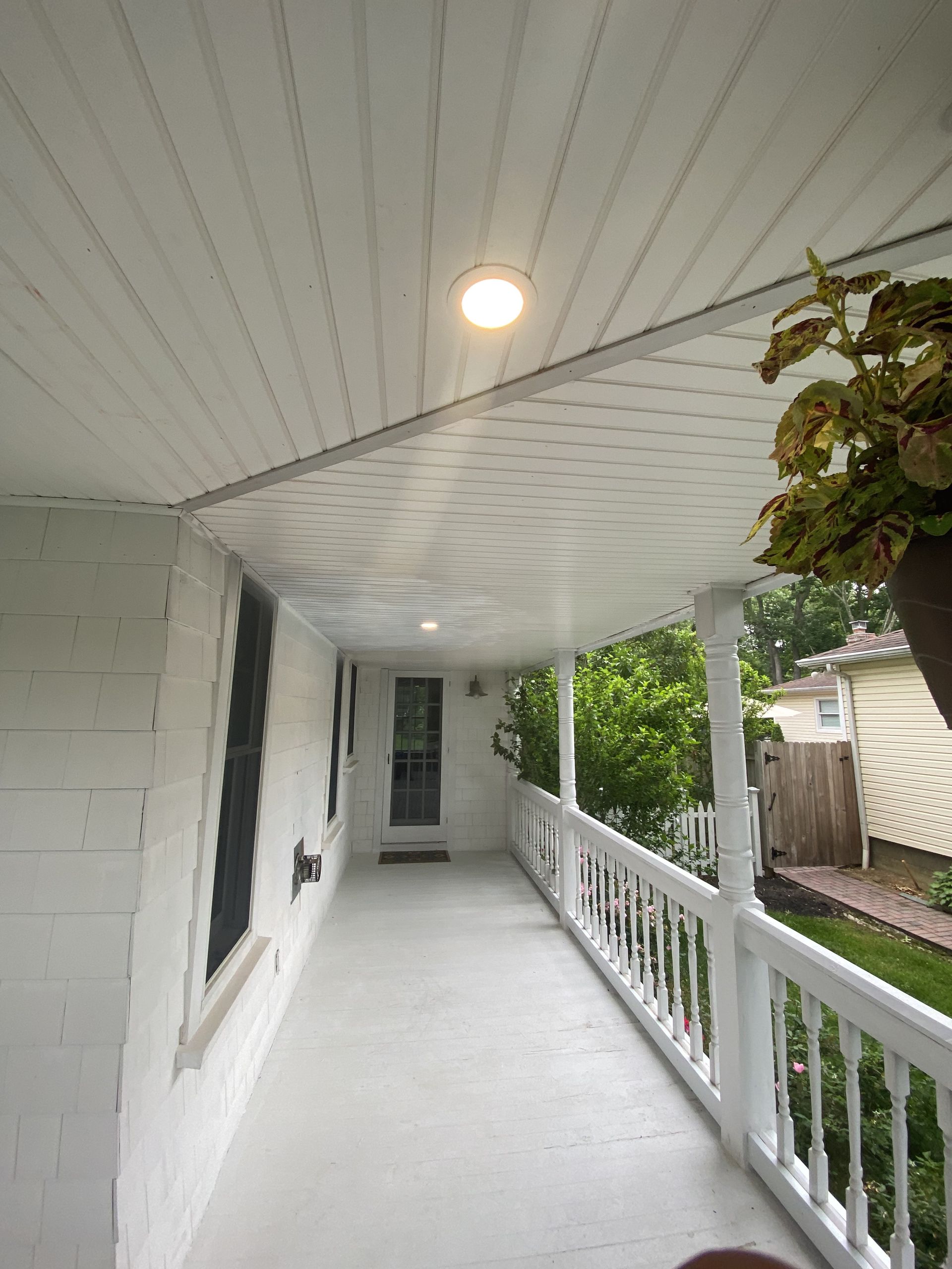 a white porch with a light on the ceiling