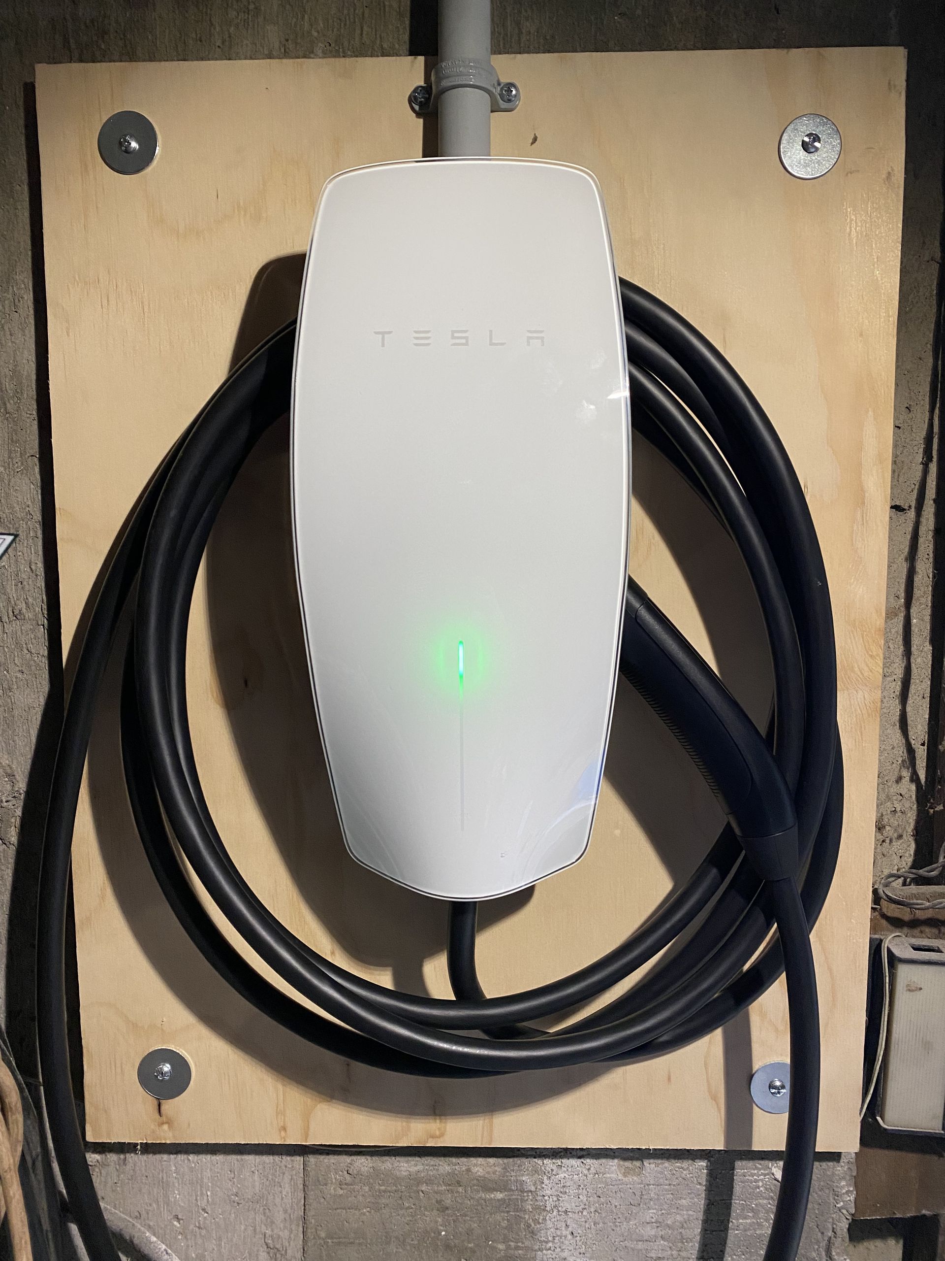 a tesla charger with a green light on it