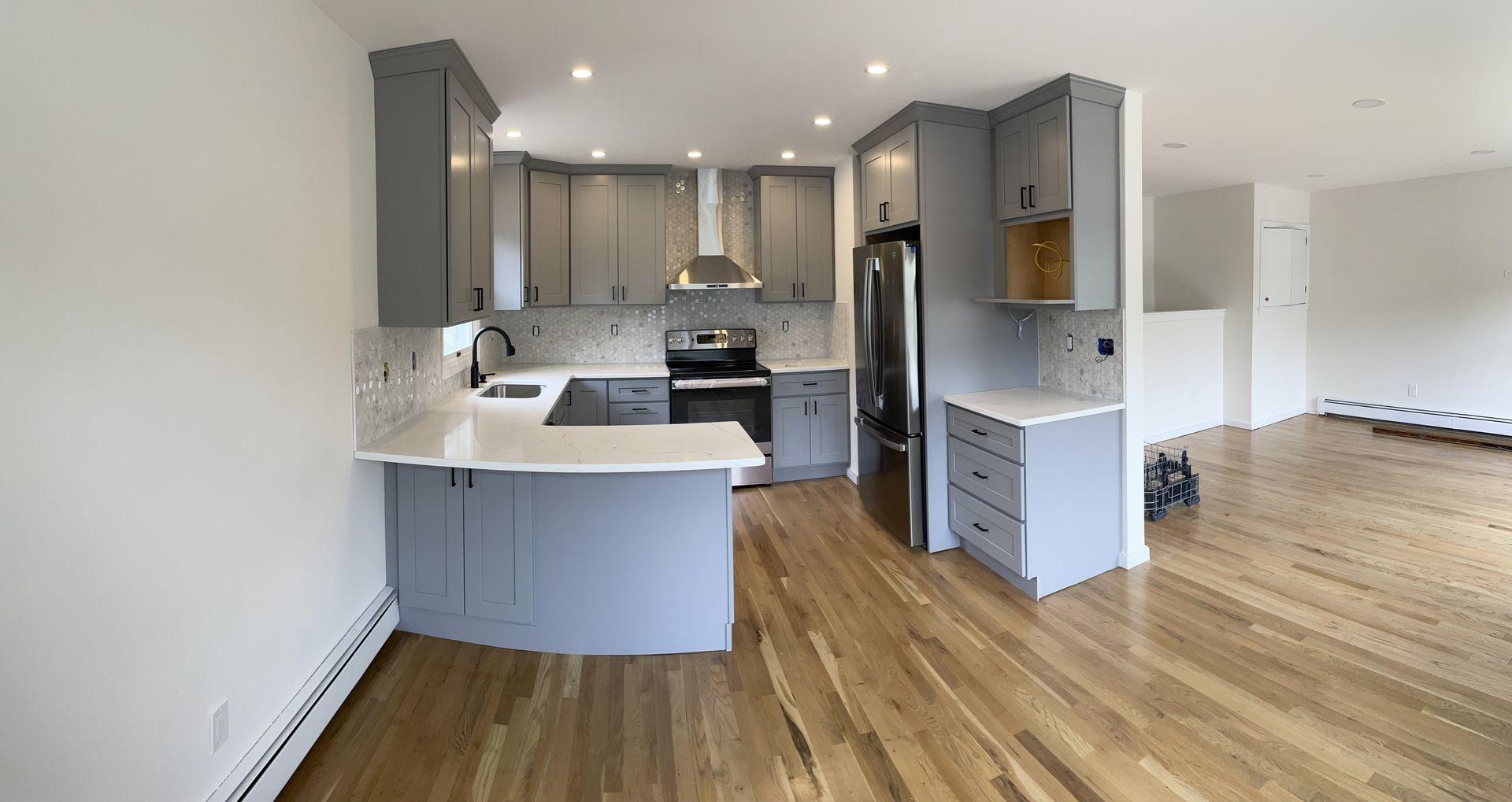 a kitchen with gray cabinets and white counter tops