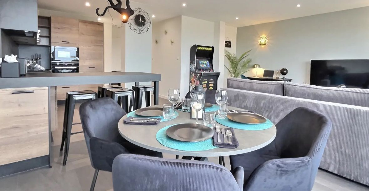 Une lampe est posée à côté d'un canapé fleuri devant un mur de briques